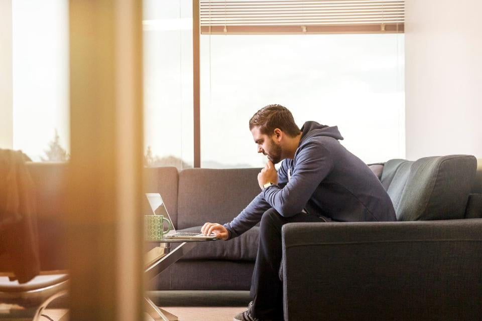 Man working on sofa from home