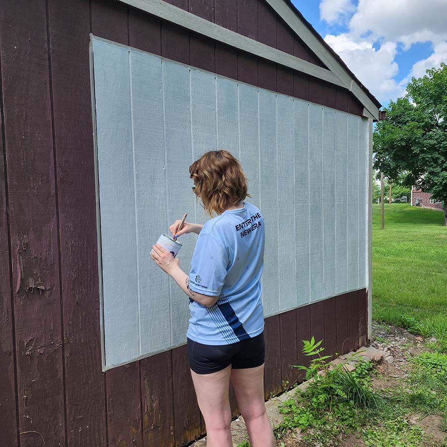 Applying outdoor projector screen paint on wooden surface